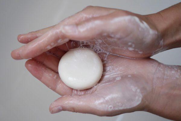Festes Shampoo in Frauenhänden mit Schaum