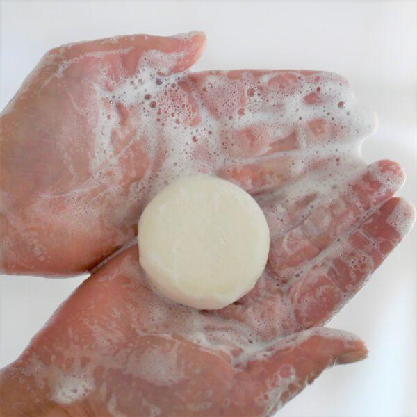 Festes Shampoo in Händen mit Schaum